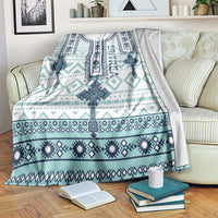 Geometric cross pattern blanket with teal and navy accents, white backing, draped on couch