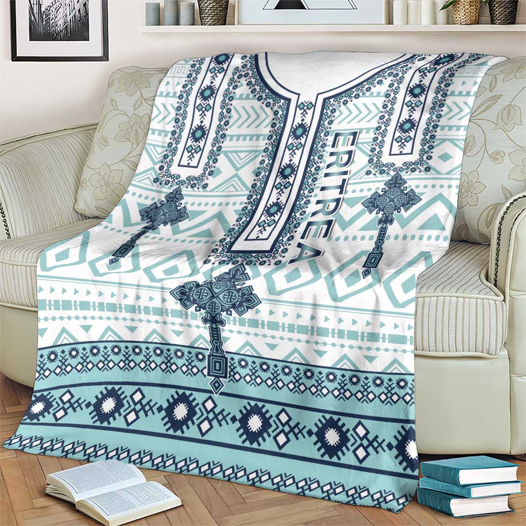 Teal and navy geometric cross pattern blanket, white top border, draped on armchair