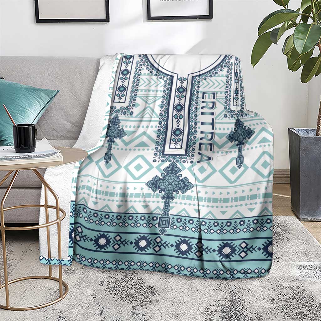 Geometric cross print blanket, teal and navy on white base, draped on gray chair