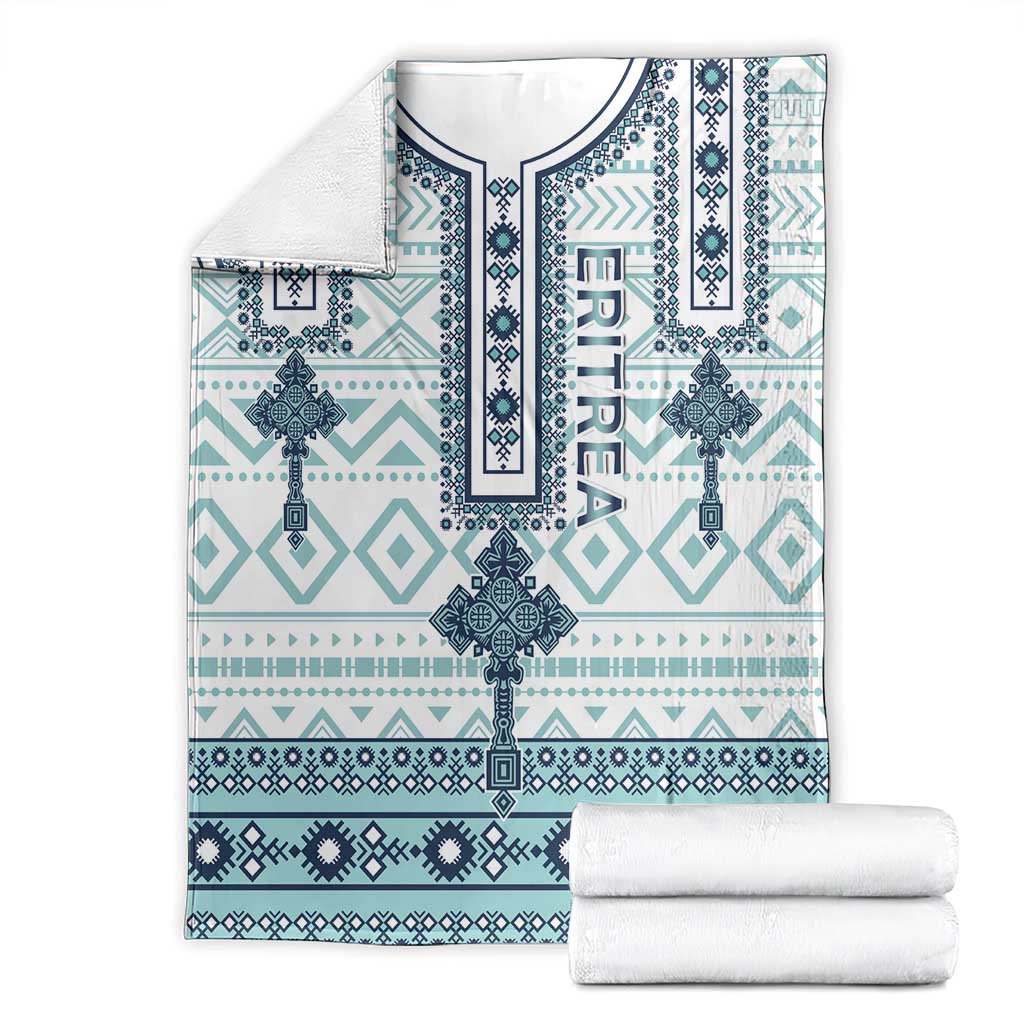 Geometric cross pattern blanket with teal and navy motifs, folded with white towels