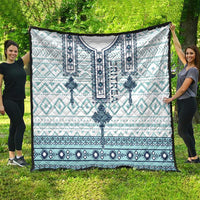 Geometric pattern quilt in white and aqua with dark blue medallion and border stripes