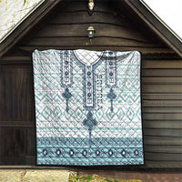 Quilt hanging on a wall: white and aqua geometric motifs with dark blue bottom band