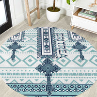 Round rug with turquoise and navy geometric cross-tile pattern, ERITREA lettering