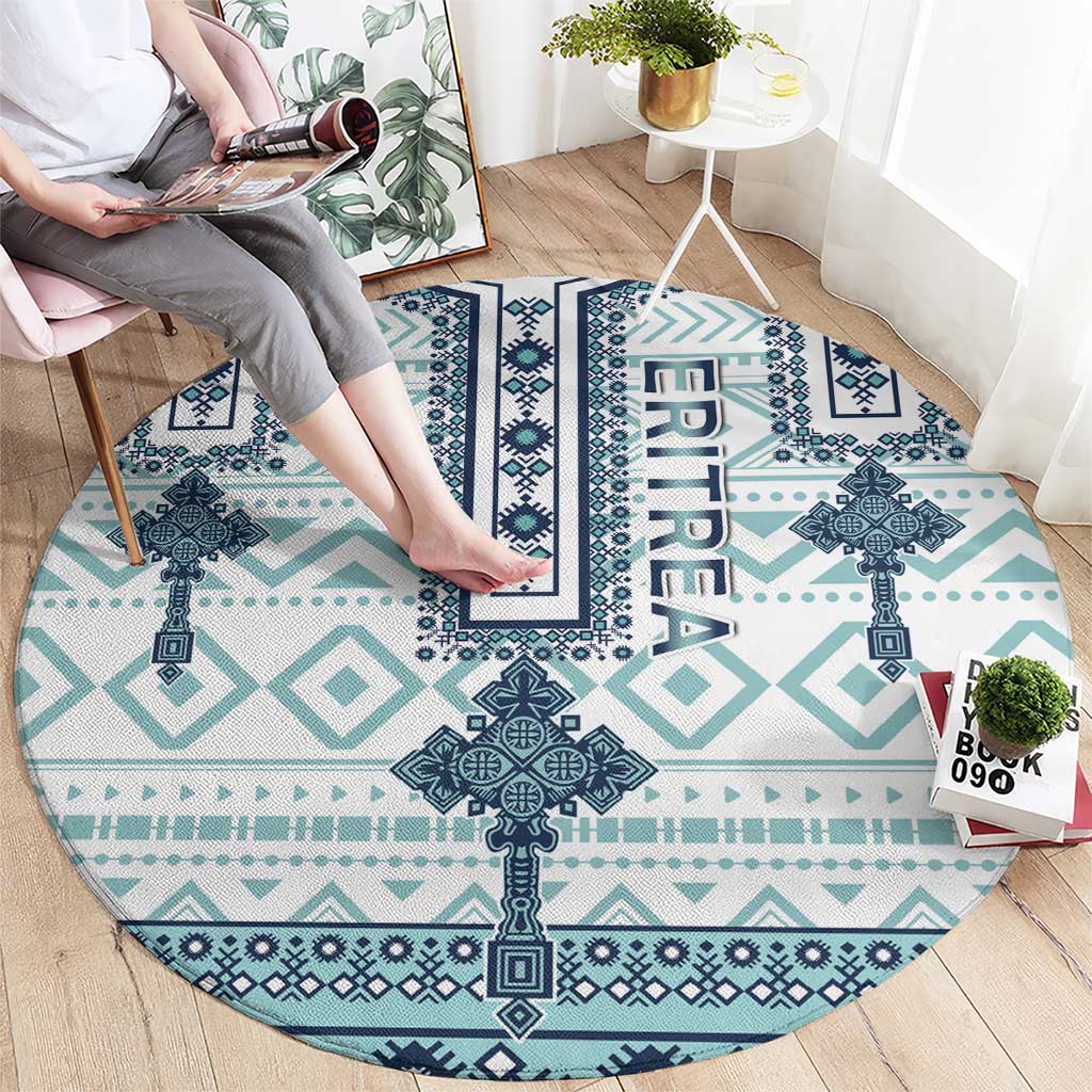 Round rug laid flat with turquoise and navy cross-tile motifs and ERITREA lettering