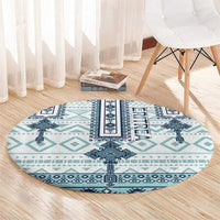 Round rug with turquoise and navy cross-tile design and ERITREA lettering in center