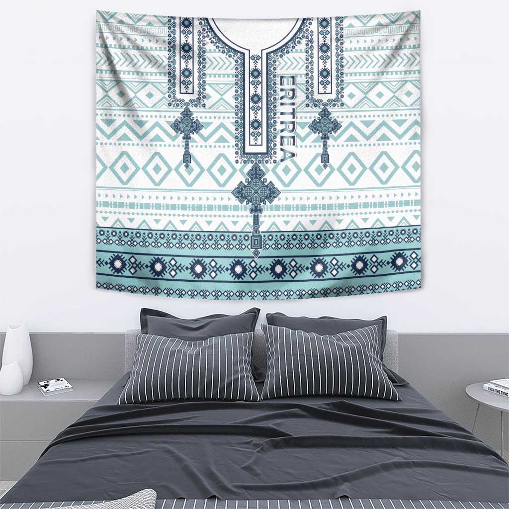 Eritrean cross tile tapestry with teal and dark-blue trim patterns, laid over bed