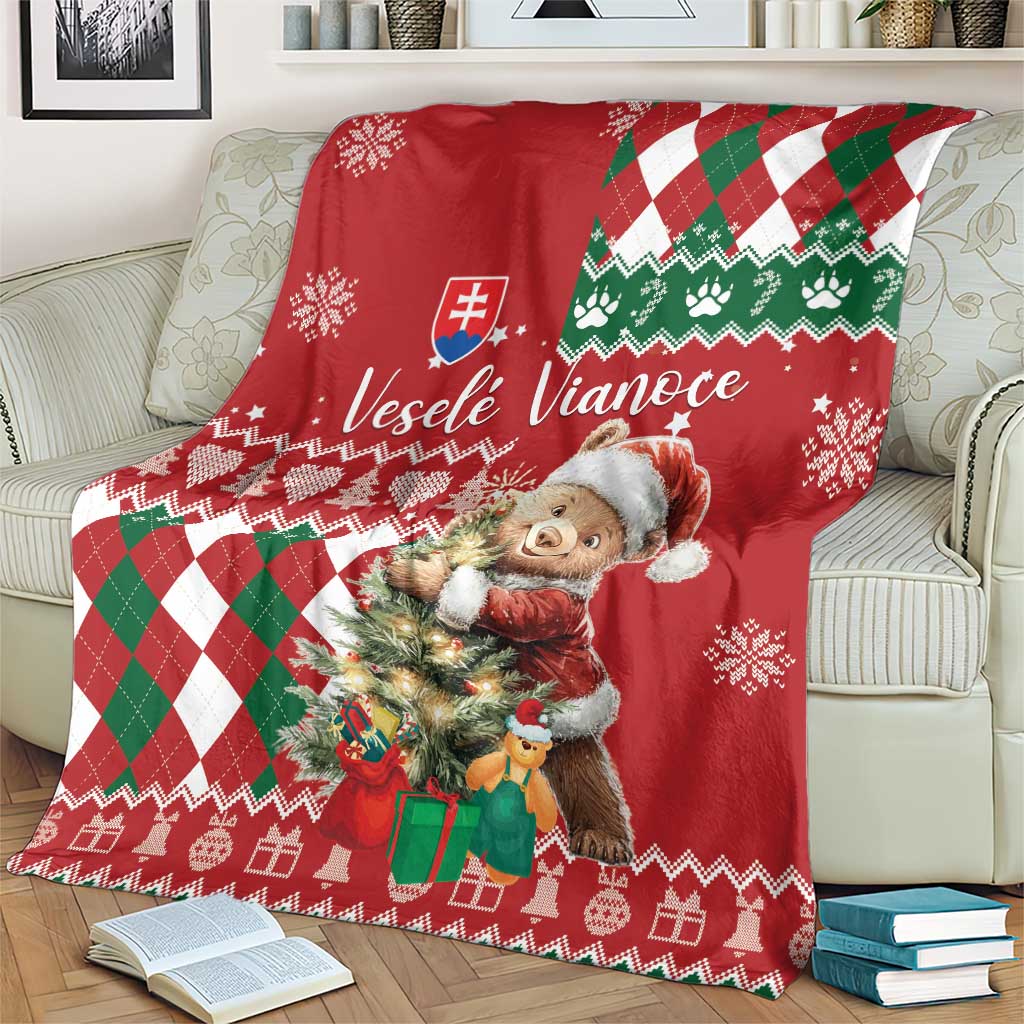 Red Christmas blanket on couch with bear illustration, green white argyle and snowflake motifs