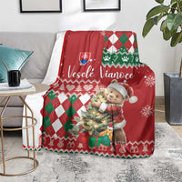 Red Christmas blanket draped over chair with bear character and green white argyle trim