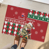 Red rubber Christmas doormat with bear holding greenery, snowflakes, and green-red diamond checks