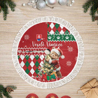 Red round Christmas tree skirt with white fringe, bear holding gift on argyle pattern