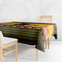 Yellow Christmas tablecloth with Krampus pattern, hanging over table edge