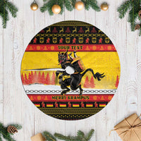 Yellow round Christmas tree skirt with fringed edge, black Krampus graphic and bands.