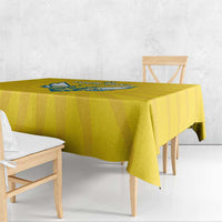 Yellow tablecloth with blue crest design on top, hanging over bench