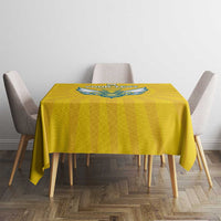 Yellow round-corner tablecloth with blue crest design on dining table center