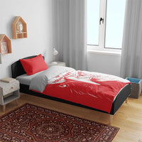 Red and white duvet with lion print and two red pillowcases on bed