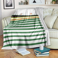 White and green striped rugby blanket with colorful patterned band and team logos
