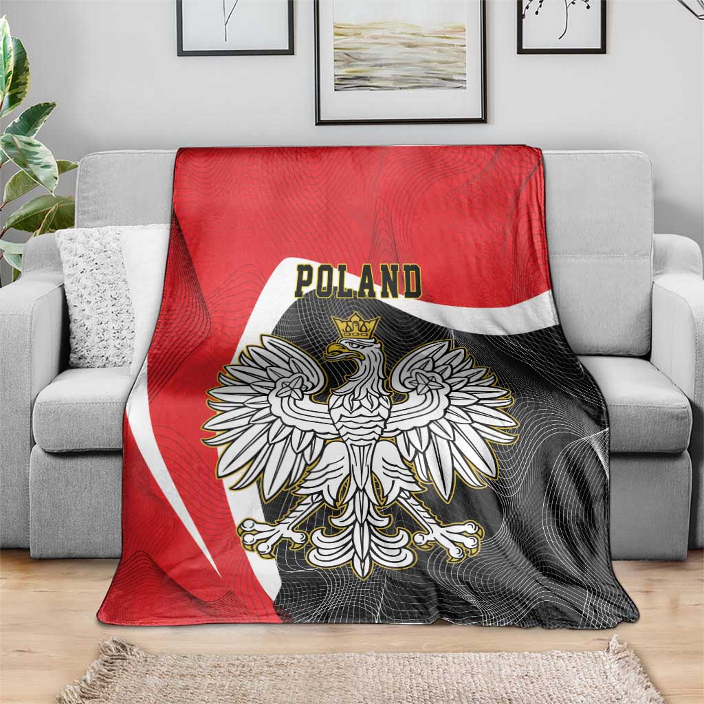 Red and black crowned eagle blanket with Poland text draped on gray sofa