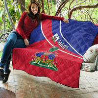 Haiti flag quilt held up by a person with blue top, red bottom, and “HAITI” stripe