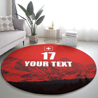 Red round football rug with Swiss cross, 17, and YOUR TEXT print on floor.