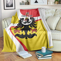 Personalized Silesia blanket with black eagle and YOUR TEXT, draped on a couch over books