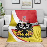 Personalized Silesia blanket with black eagle and YOUR TEXT, draped over a sofa with red-yellow-white stripes