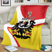 Personalized Silesia blanket with black eagle and YOUR TEXT on red, yellow, white flag stripes, on a sofa