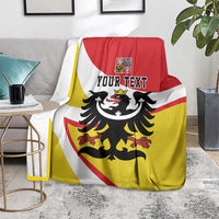 Personalized Silesia blanket with black eagle and YOUR TEXT, draped on a sofa in red-yellow-white stripes