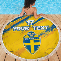 Yellow round beach blanket with blue Sweden crest and "YOUR TEXT", white fringe edge.