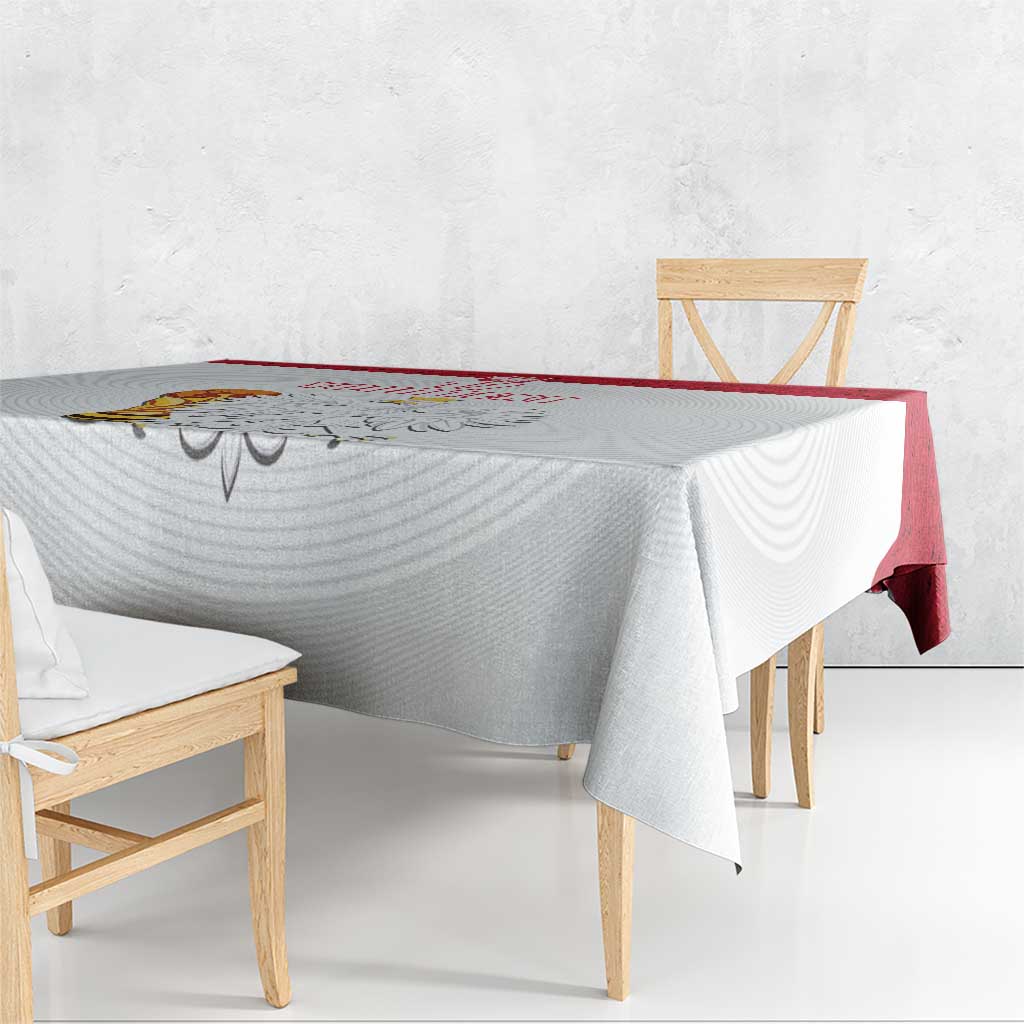 White tablecloth with red border and printed crest, hanging over chair-height edge