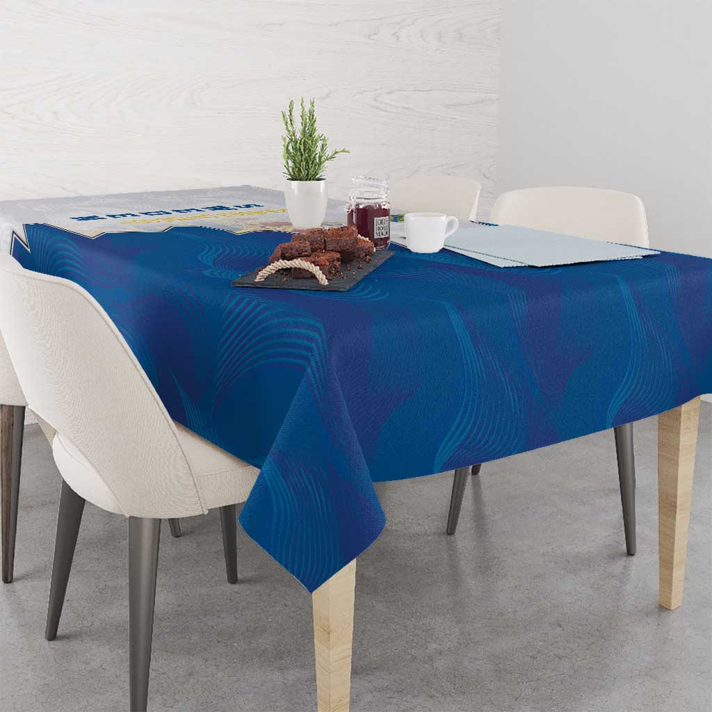 Blue tablecloth with coat of arms emblem on corner, spread across rectangular table