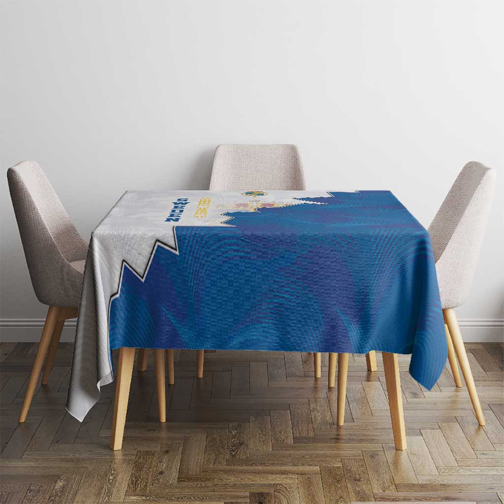 Blue and gray tablecloth with coat of arms crest, square table with draped corners