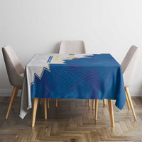 Blue and gray tablecloth with coat of arms crest, square table with draped corners