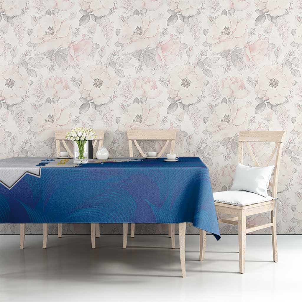 Blue tablecloth with coat of arms crest, on dining set with white chairs