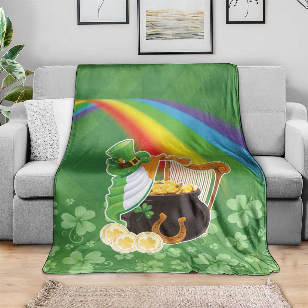 Green throw blanket on sofa with harp, pot of gold, rainbow stripe and clover pattern