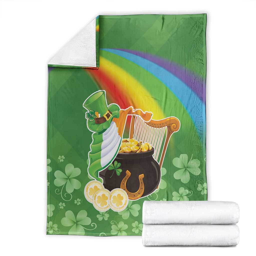 Green throw blanket with harp and pot of gold design, rainbow stripe, stacked white rolls