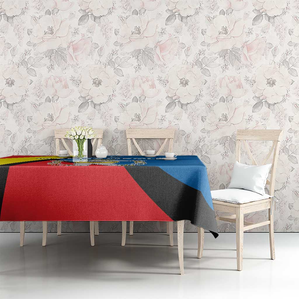 Dining table tablecloth featuring red, blue, and yellow diagonal pattern with emblem.