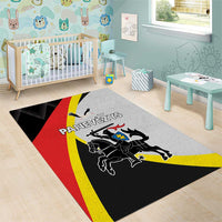 Black area rug with red and yellow diagonal flag stripes and crest artwork