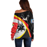 Women’s off-shoulder sweater, black with red-yellow-white diagonal stripes and bird graphic