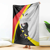 Black, red, and white blanket with yellow diagonal stripe and running cartoon animal design