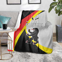 Black, red, and yellow blanket draped on a sofa with large running animal graphic