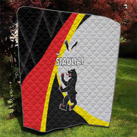 Folded quilt showing black, red, white and yellow panels with SIAULIAI graphic