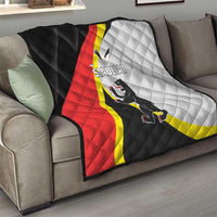 Quilt draped over couch with black, red, white and yellow panels and SIAULIAI text