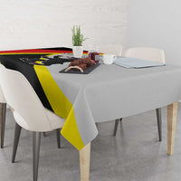 Black tablecloth with yellow diagonal stripe and red border, crest graphic visible