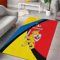 Yellow area rug with Taurage crest, red center, blue border, and black diagonal shapes