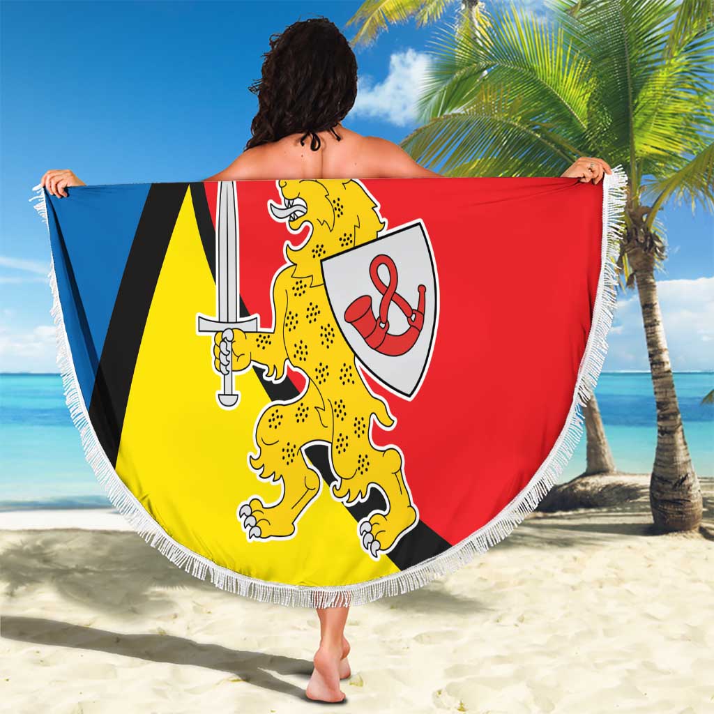 Round beach blanket with fringe featuring Taurage coat of arms in blue, black, red, and yellow.