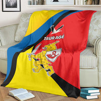 Taurage blanket over a sofa arm, yellow, blue, and red flag colors with crest