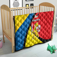 Taurage-themed quilt on a crib, yellow blue red panels with black diagonal stripe