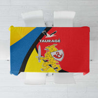 Yellow, blue, black and red diagonal patterned tablecloth with crest graphic.