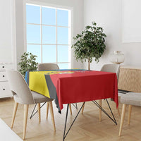 Diagonal yellow, blue and black with red patterned tablecloth on dining table.