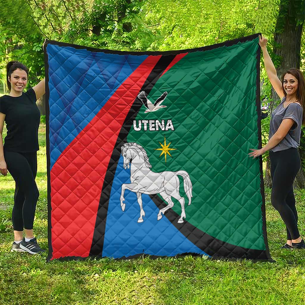 Large quilt blanket hung outdoors, blue red green panels with horse and Utena logo